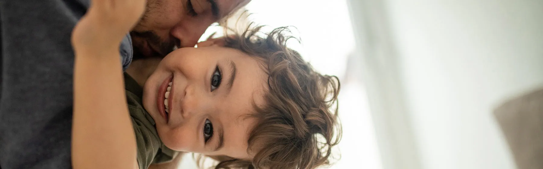 Enfant qui rit dans les bras de son père