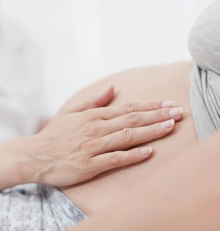 Main posée sur le ventre d'une femme enceinte