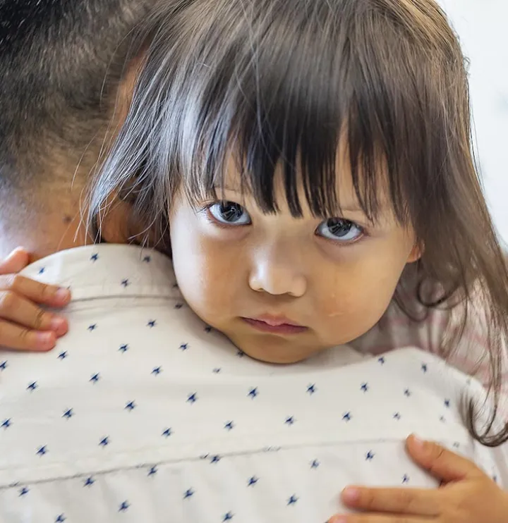 Petite fille qui pleur porté par son papa