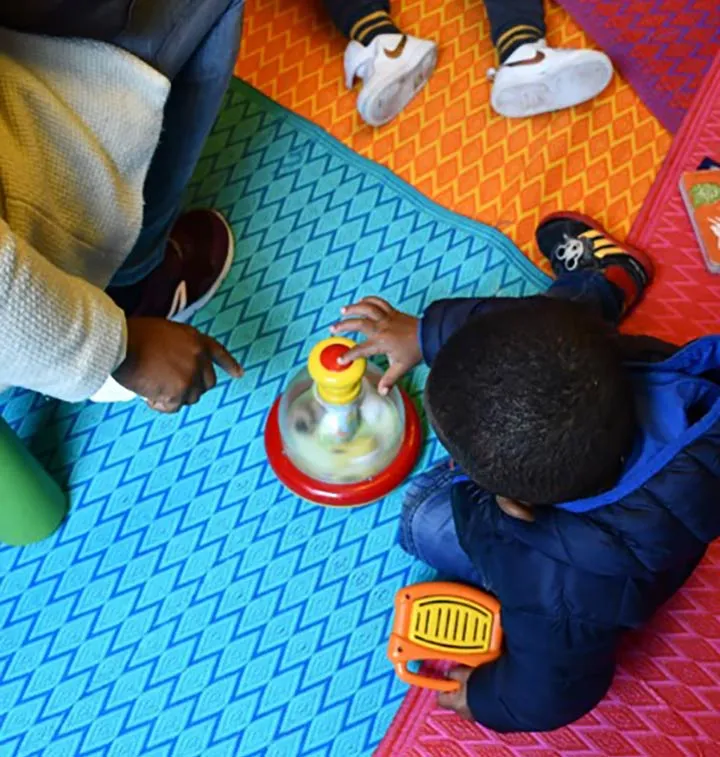 Enfant qui joue sur un tapis coloré