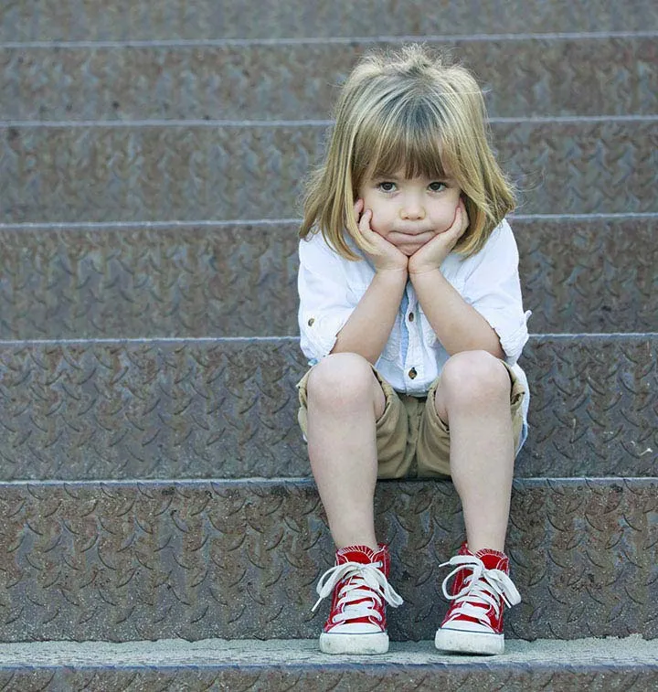 Petite fille triste assise sur des marches