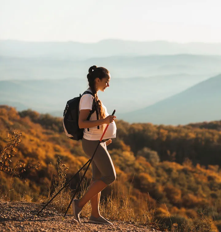 femme enceinte qui randonne dans un paysage de montagne à l'automne