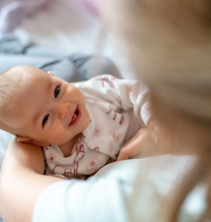 Bébé dans les bras d'une puéricultrice