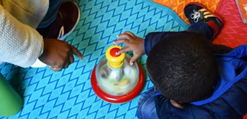Enfant qui joue sur un tapis coloré