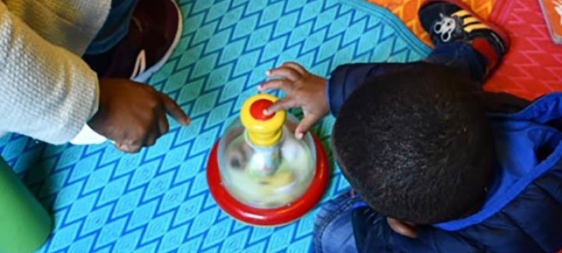 Enfant qui joue sur un tapis coloré