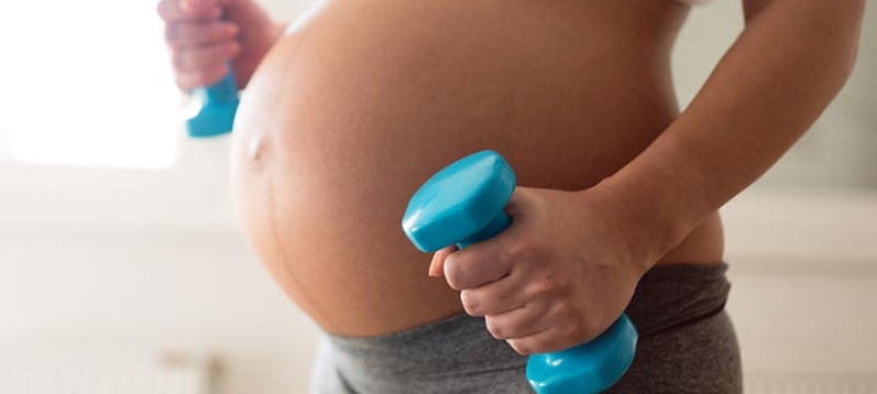Femme enceinte avec des haltères