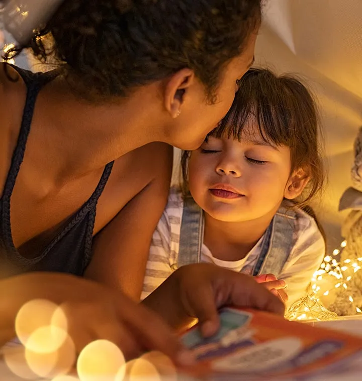 Une femme embrasse le front d'une petite fille