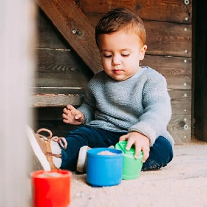 Bébé qui joue avec des petits seaux de couleur