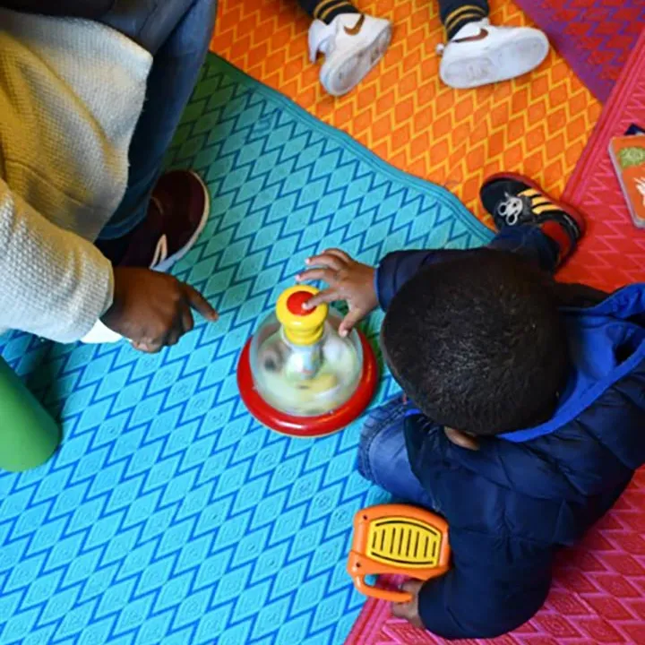 Enfant qui joue sur un tapis coloré