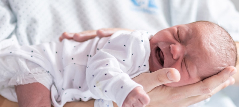 nouveau-né posé sur le bras de sa maman